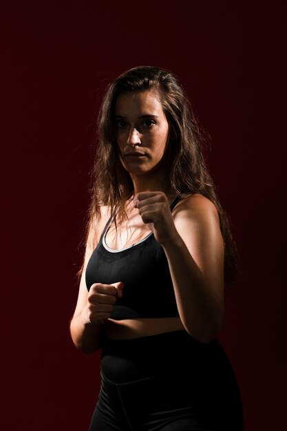 Medium shot fit woman with long hair looking at the camera