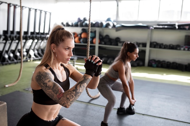 Medium shot fit women training at gym