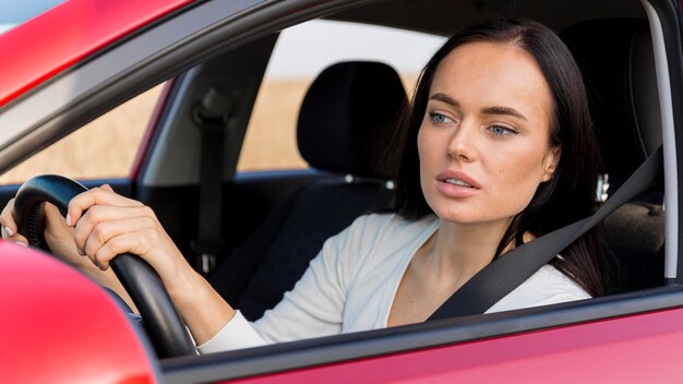 Medium shot focused woman driving