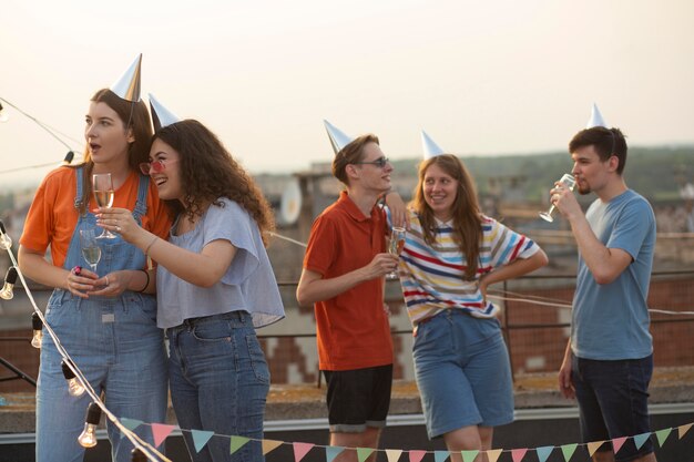 Free photo medium shot friends celebrating with hats