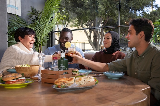 Medium shot friends clinking glasses