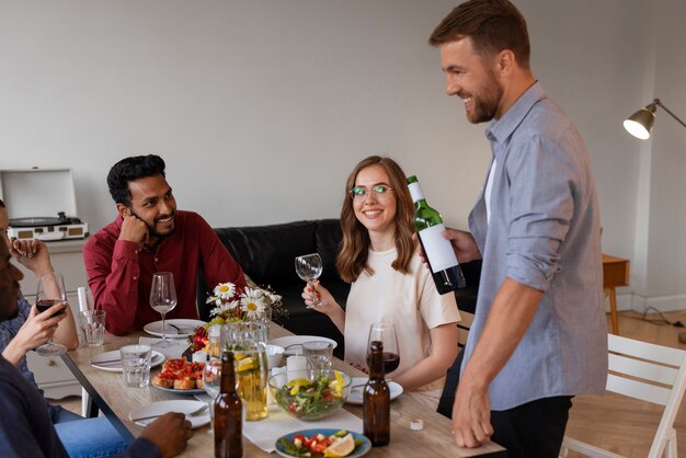 Free photo medium shot friends at dinner party