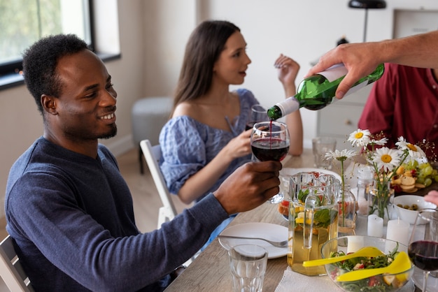 Free photo medium shot friends at dinner party