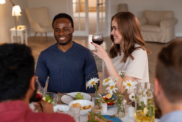 Free photo medium shot friends at dinner party