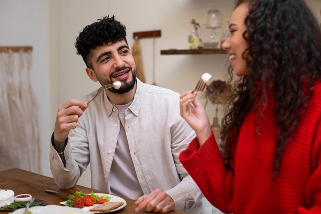 Free photo medium shot friends eating fresh cheese