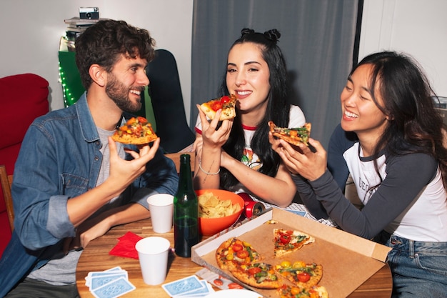 Free photo medium shot friends eating pizza