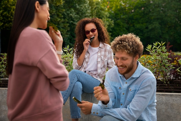 Free photo medium shot friends eating seaweed snacks