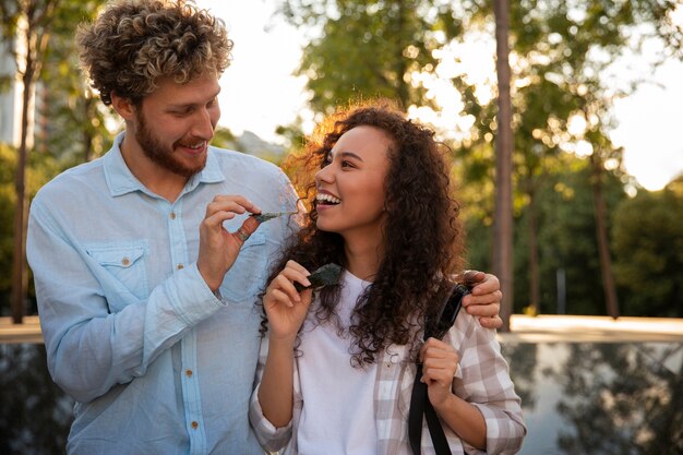 Free photo medium shot friends eating seaweed snacks