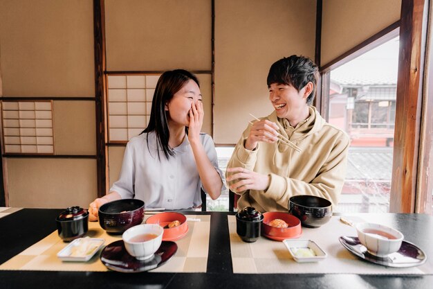 おいしい食べ物を食べるミディアムショットの友達