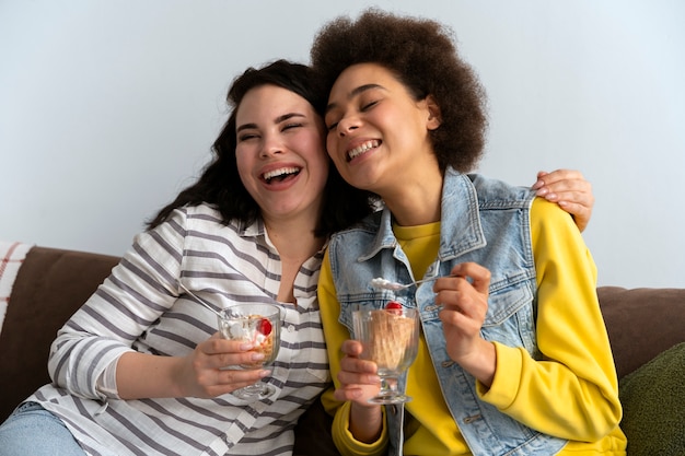 Free photo medium shot friends eating tasty ice cream