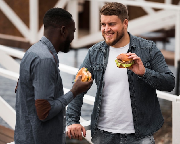 Medium shot friends holding burgers