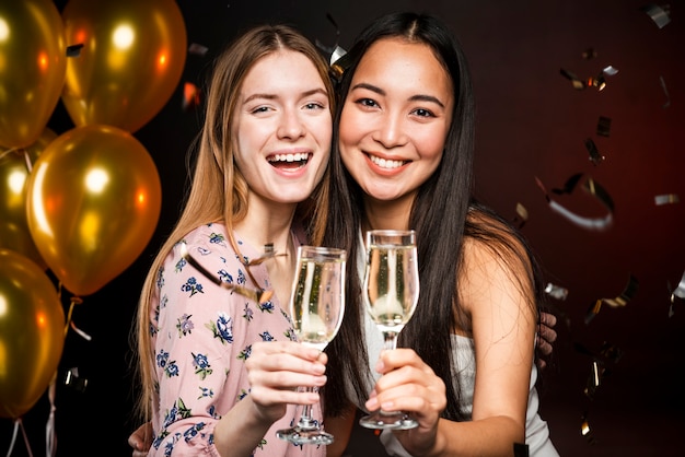 Free photo medium shot of friends holding champagne glasses