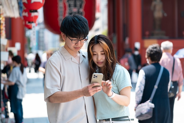 Medium shot friends holding smartphone