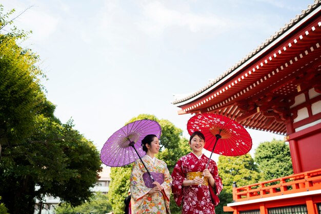 Medium shot friends holding wagasa umbrella