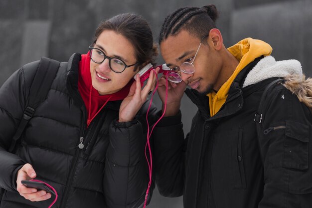 Medium shot friends listening to music outdoors