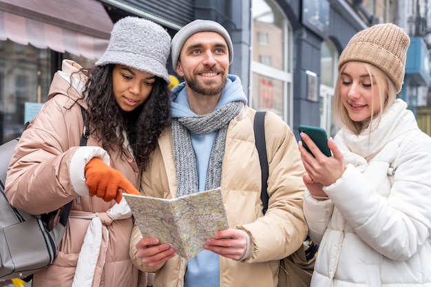 Medium shot friends looking at map