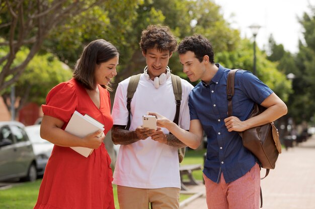 Medium shot friends looking at phone