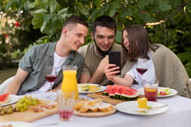 Medium shot friends looking at phone