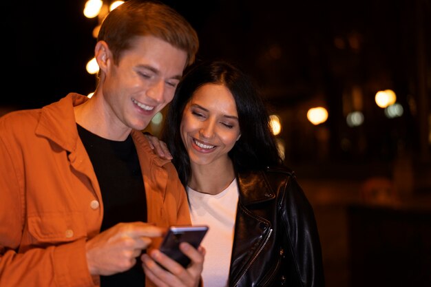 Foto gratuita amici di tiro medio che guardano il telefono