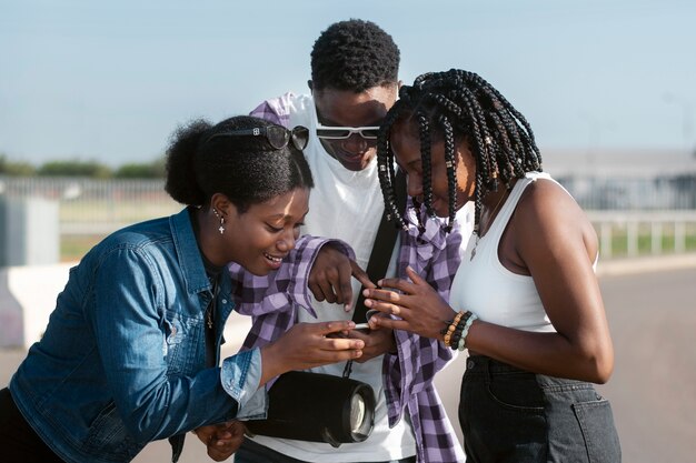 Medium shot friends looking at phone