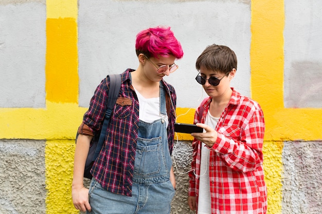 Amici di tiro medio guardando smartphone