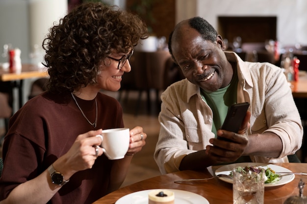 Amici di tiro medio guardando smartphone