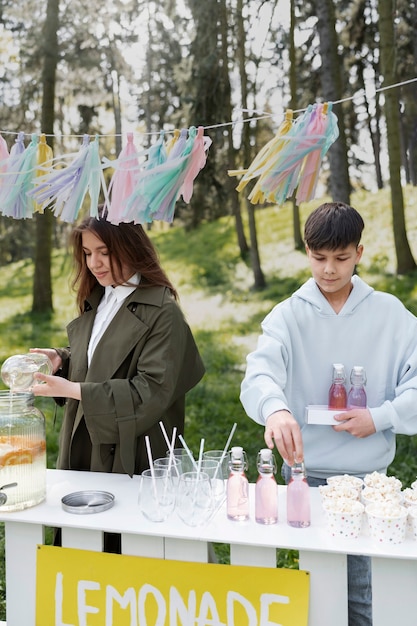 Medium shot friends making lemonade outdoors