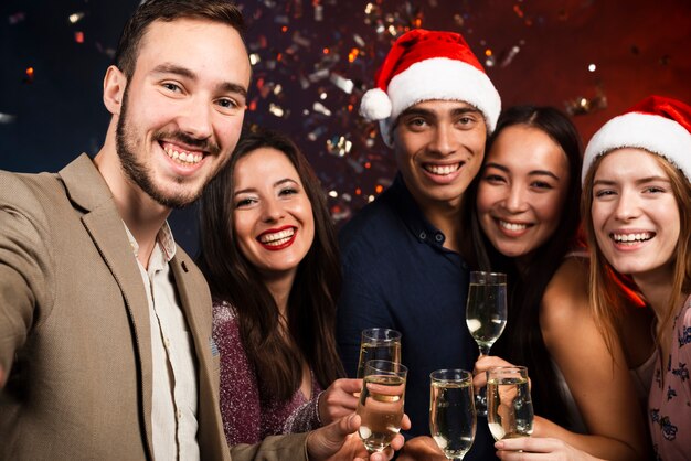 Средний снимок друзей на новогодней вечеринке с бокалами шампанского