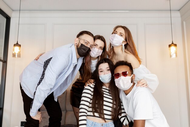 Medium shot friends at party wearing face masks