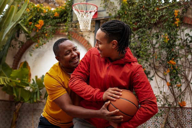 Free photo medium shot friends playing basketball outdoors