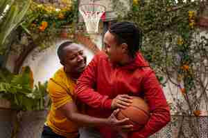 Foto gratuita amici di tiro medio che giocano a basket all'aperto