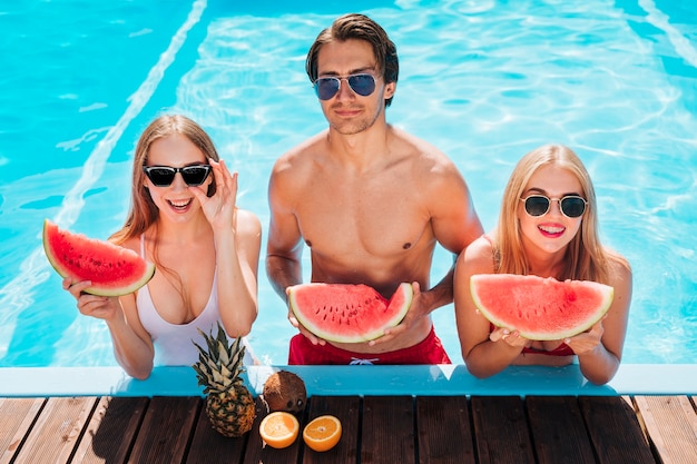 Free photo medium shot friends posing with watermelon