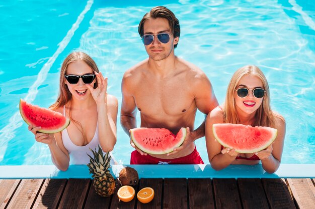 Medium shot friends posing with watermelon