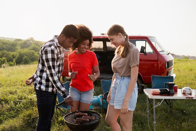 Foto gratuita amici di tiro medio che preparano il barbecue