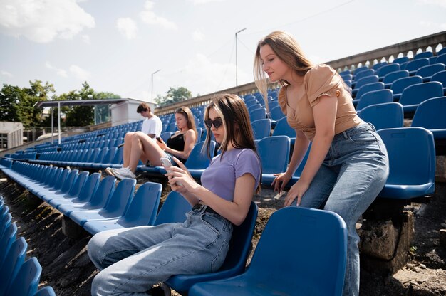 Medium shot friends sitting on chairs