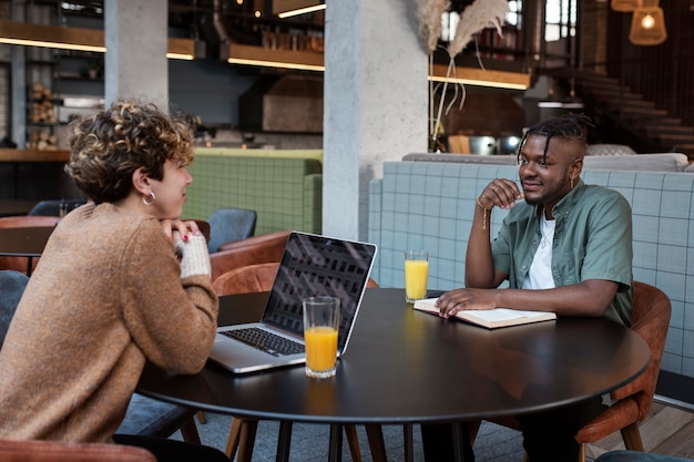 Medium shot friends sitting in coffee shop