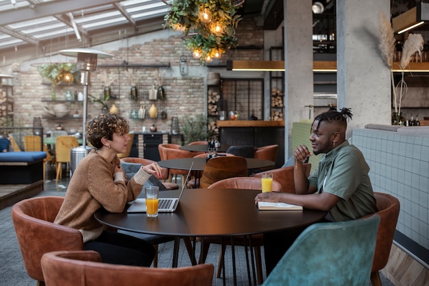 Medium shot friends sitting in coffee shop