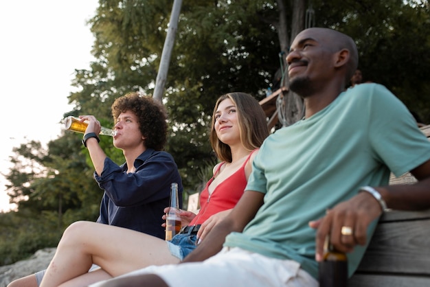 Medium shot friends sitting outdoors