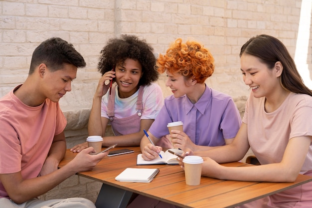 Free photo medium shot friends sitting at table