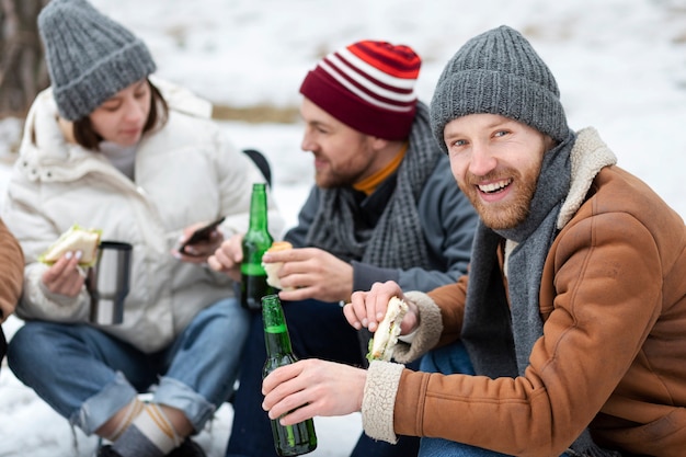 Medium shot friends sitting together in nature