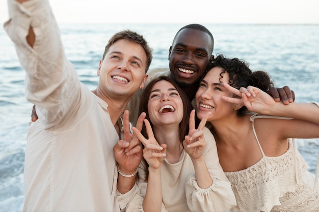 Medium shot friends taking selfie on beach