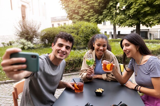 Medium shot friends taking selfie