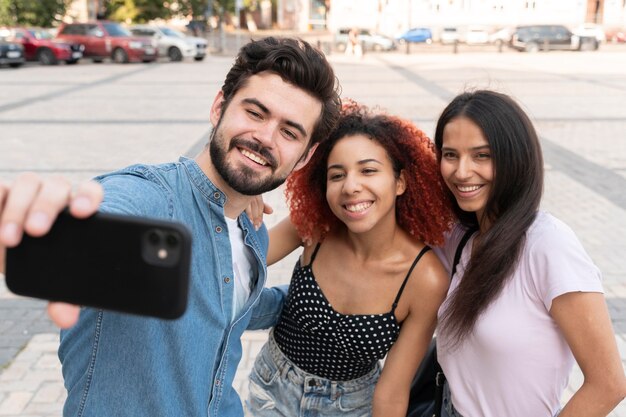 Medium shot friends taking selfies
