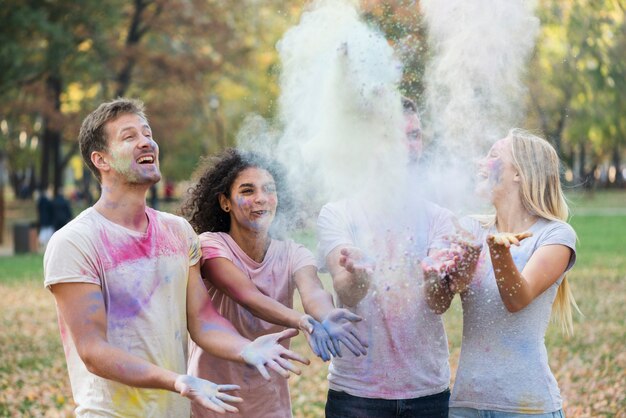 Medium shot of friends throwing powder in the air