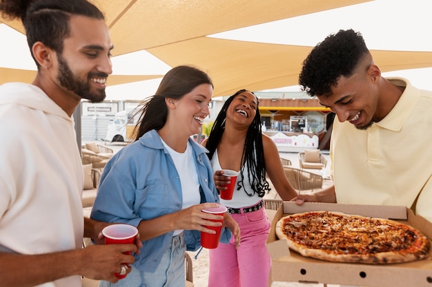 Medium shot friends with delicious pizza