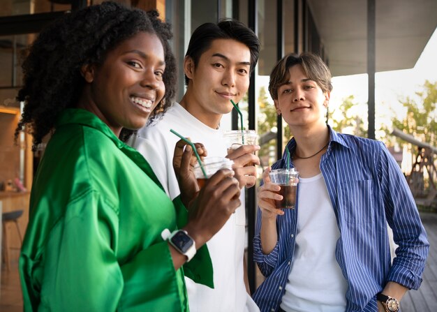 Medium shot friends with iced coffee