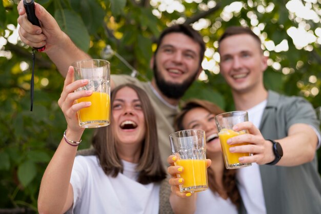 Medium shot friends with juice glasses