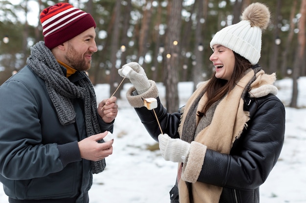 Medium shot friends with marshmallows outdoors