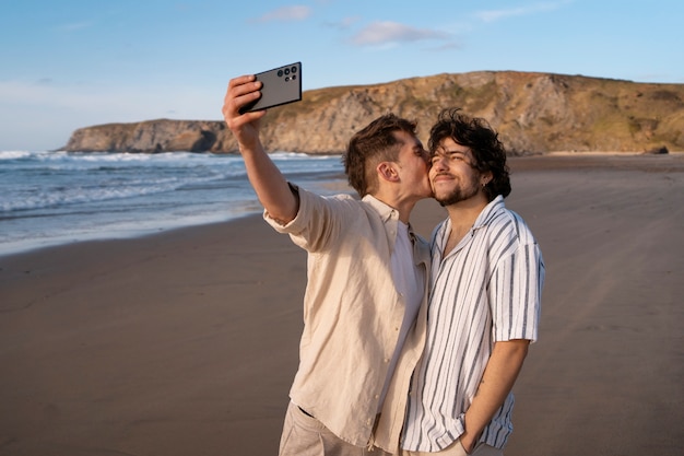 Foto gratuita coppia gay a tiro medio che si fa selfie