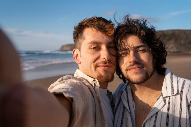 Foto gratuita coppia gay a tiro medio che si fa selfie